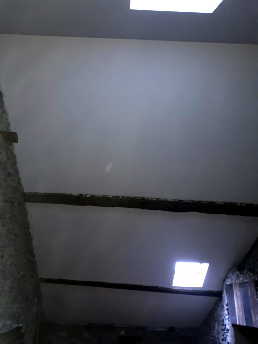 Plafond et rampants lisses en plaques de plâtre avec deux fenêtres de toit